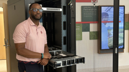 Jevon Smith with the Grace Hopper supercomputer in the Plant Sciences Building at NC State.