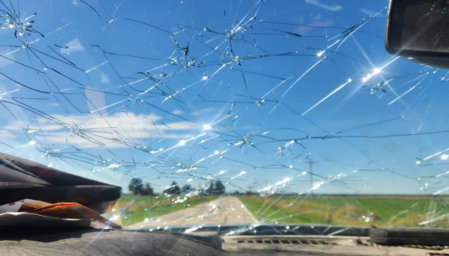 A pickup windshield shows the devastation caused by the hail.