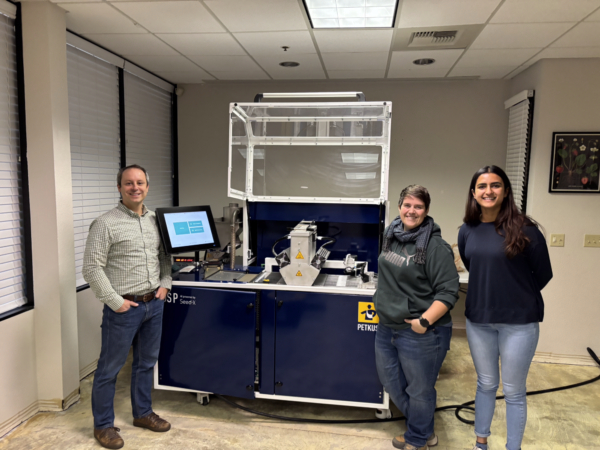 From left to right, Jim Schweigert, president; Meck Slagle, vegetable seed improvement lead; and Khushi Chawda, market development intern, standing in front of the Seed-X machine at the new Davis location.