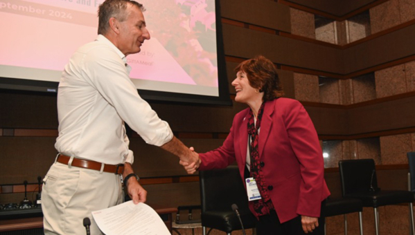 Karen Plaut, Purdue executive vice president for research [right], shakes hands with Robert Reiter, Bayer head of crop science research and development, after signing an agreement Sept. 19 in St. Louis, MO creating the Coalition for Sustainable and Regenerative Agriculture. (Photo courtesy of Bayer)