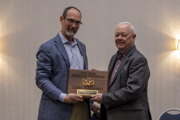 Larry Richardson receives the Outstanding Achievement in Sorghum Improvement Award from Tim Lust.
