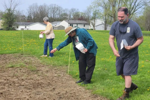 Volunteers and community members help Greg Kedzierski (far right) spread native seed at planting site. (Amber Stilwell, Penn State Extension)