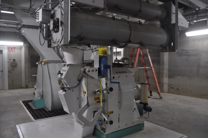 Buhler 3-5 tph mill with steam conditioner in the foreground with Buhler paddle-type 2-ton mixer behind it.