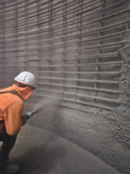A CCS crew placing wet shotcrete over a reinforced steel structure.