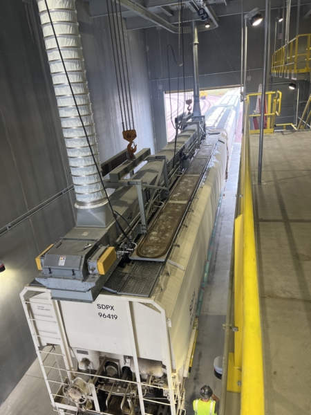 Two 10-ton winches position the conveyor over the railcar while a telescoping spout, drag conveyor and hydraulic spreader system ensure even car fill.