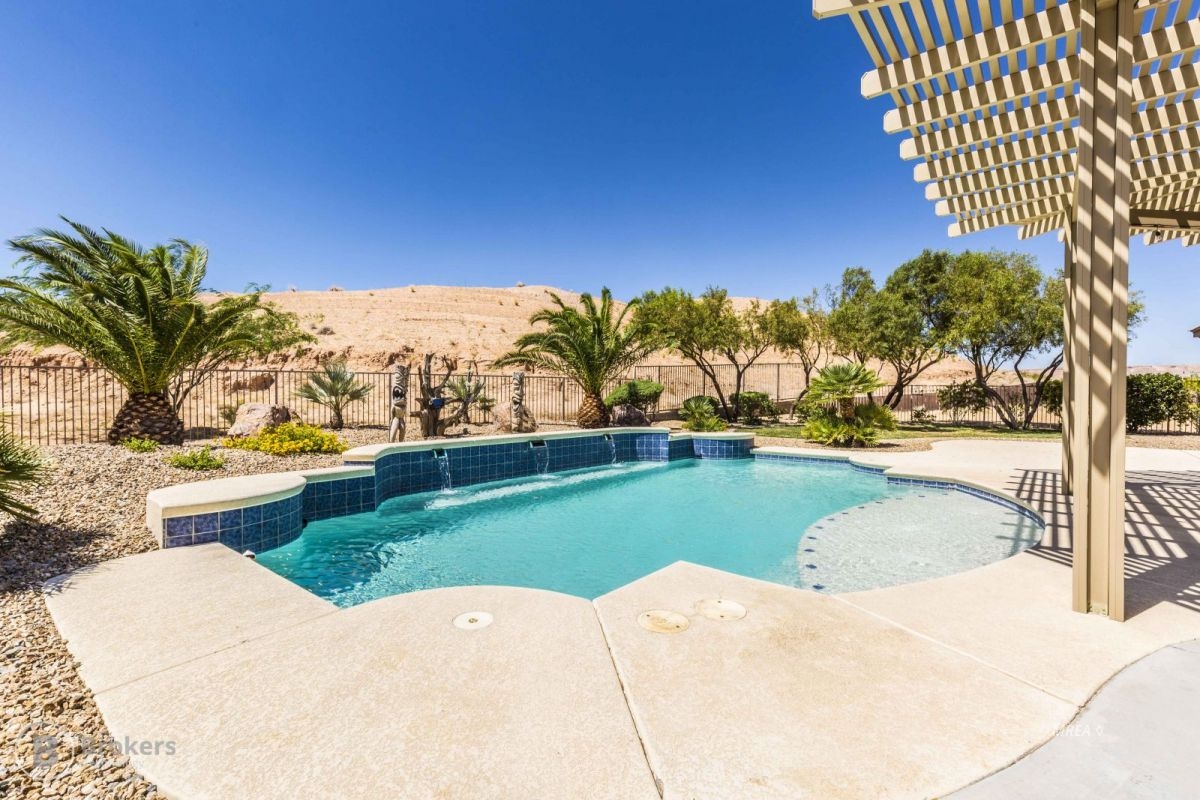 26754 As you pull up to this exquisite home situated on a .44 acre lot, you'll notice the great curb appeal and care this home has had. Enter the courtyard, and walk thru the foyer, you'll be impressed with the natural lighting of the home, and the views of the mountains and swimming pool across the open floor plan. No detail has been left undone, you'll find upgrades throughout the house. A few include the upgraded Knotty Alder Cabinets, rough edged granite countertops, and undercabinet lighting in the kitchen. You'll be surprised when you see the large hidden pantry with additional cabinets and a built--in beverage cooler. The master en-suite bathroom has a beautifully tiled and glass block walk in shower, and an oversized Jacuzzi tub. The living room, den and patios have all been pre-wired with speakers installed. There is plenty of storage with the shelving available in the pantry and laundry room. Exterior upgrades feature stamped concrete, an extended covered patio, accent lighting and a fully fenced yard, not to mention the swimming pool! There is also a Sewer Dump, Water, and 50 AMP Power for your RV. This is house is a must see to appreciate everything it has to offer.