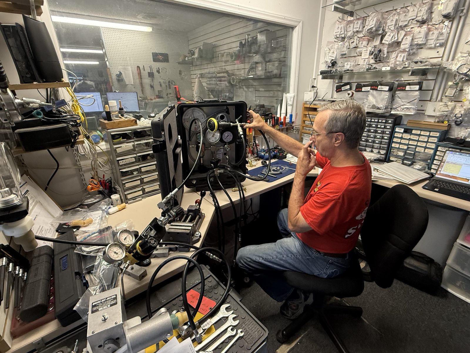 Technician testing an Interspiro breathing system on the Spiromatic test bench in the Sink or Swim Scuba service room in Gastonia, NC