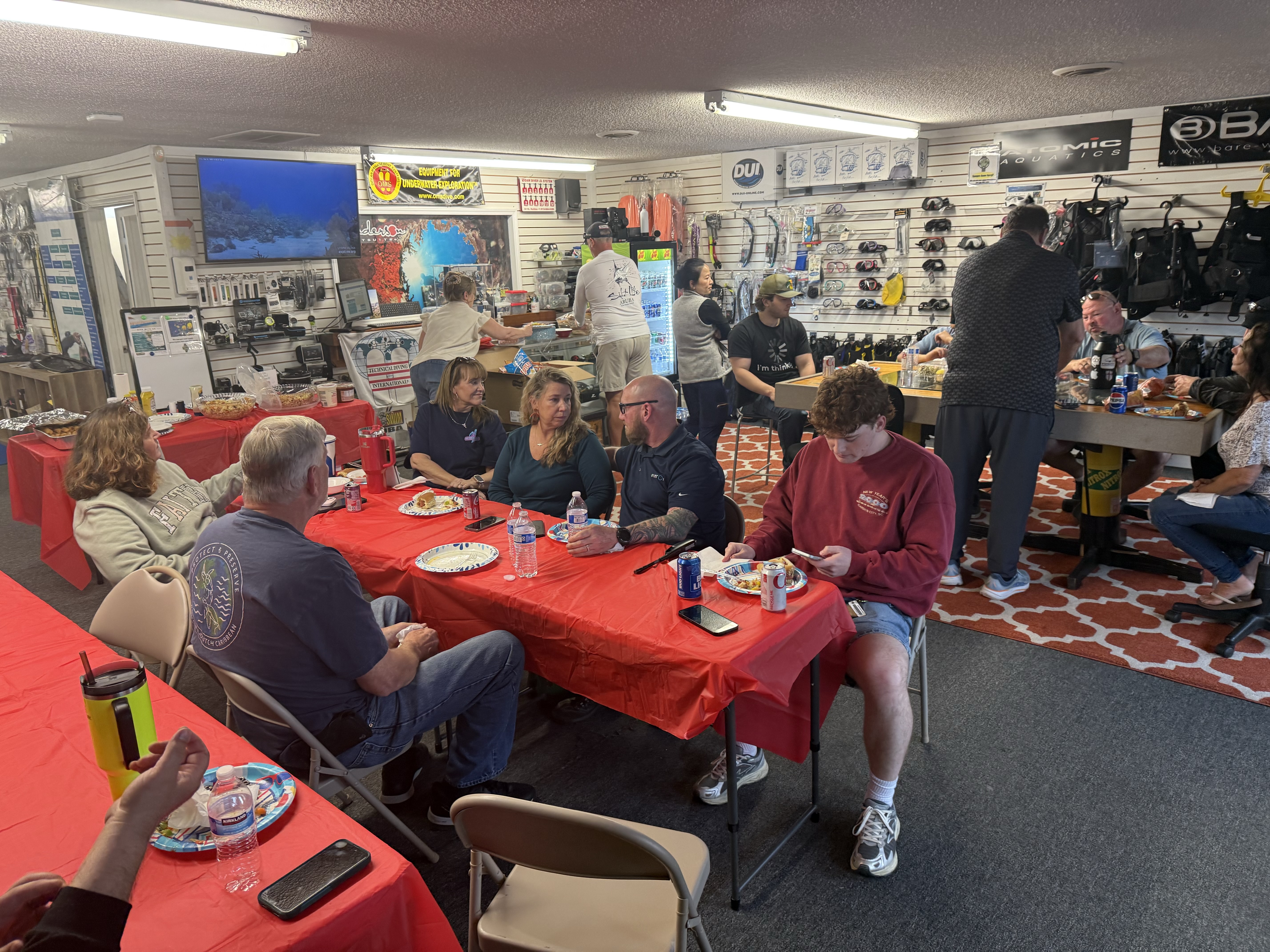 Divers and students socializing during a pre-trip scuba diving community gathering at Sink or Swim Scuba in Gastonia, North Carolina.