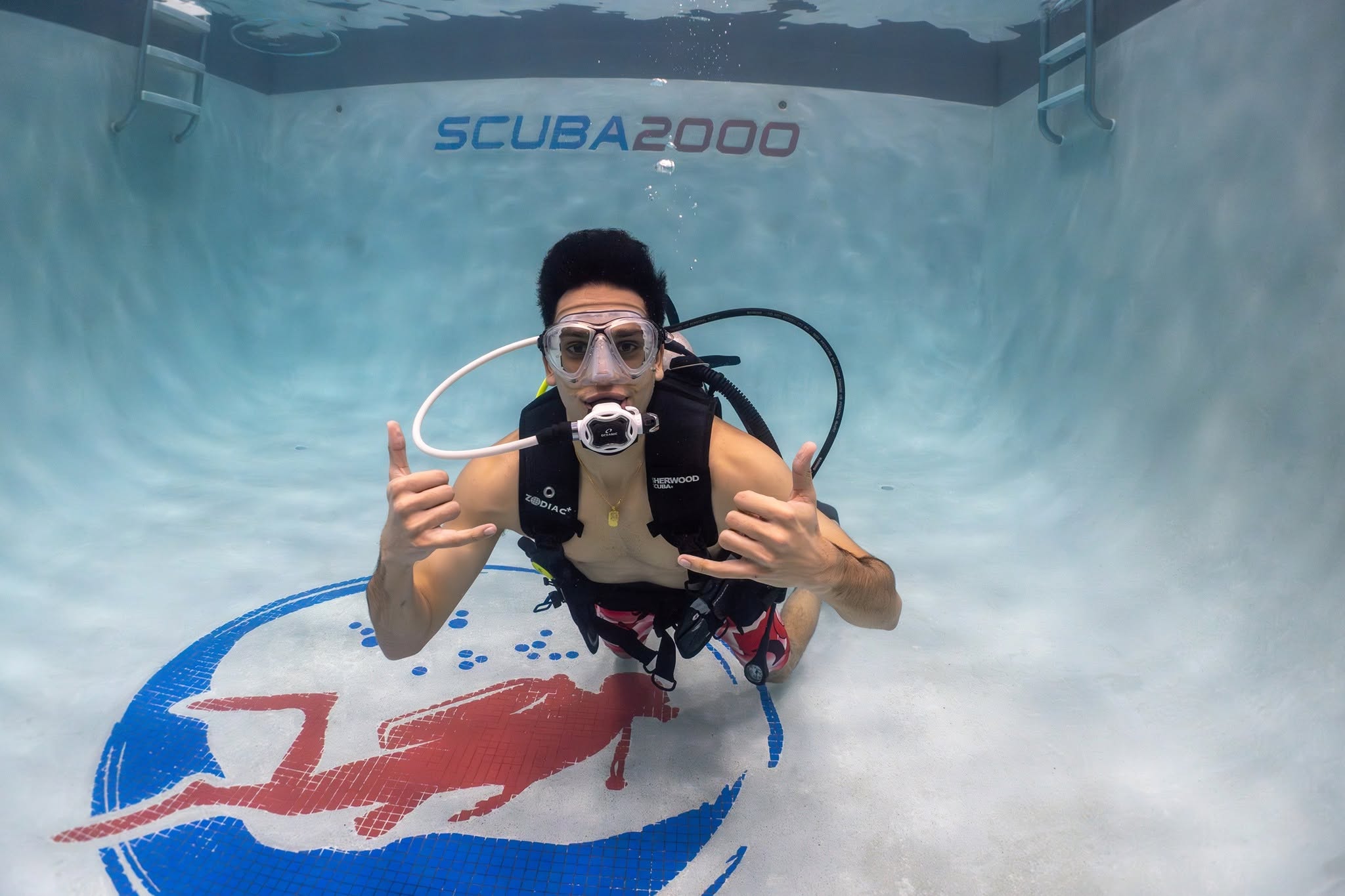 A scuba student giving shaka signs in the Scuba 2000 training pool