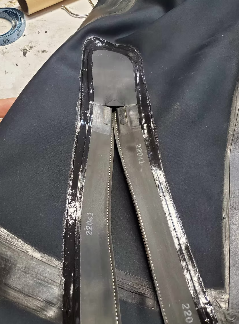 Close-up of a drysuit zipper and surrounding seam during repair