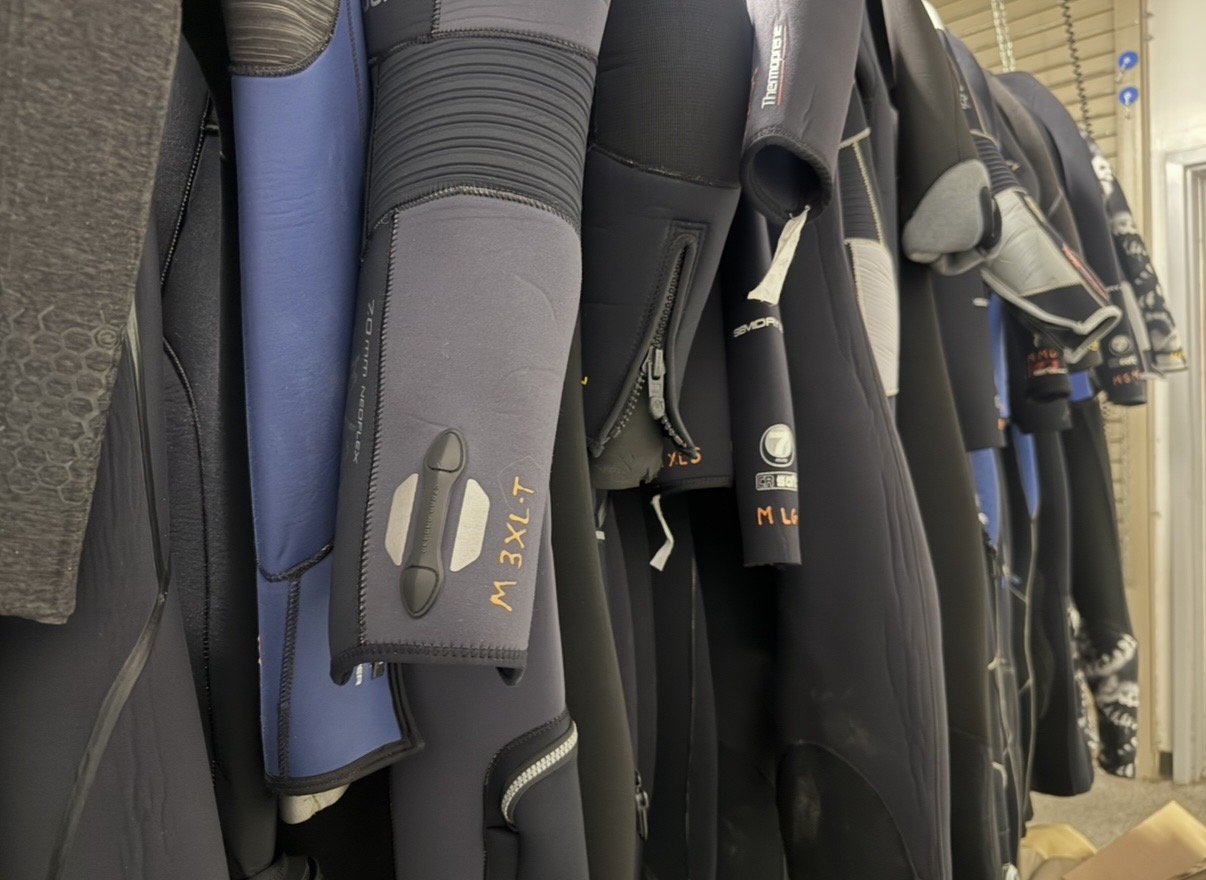 Wetsuits in a range of sizes on the Dive Arizona rental rack