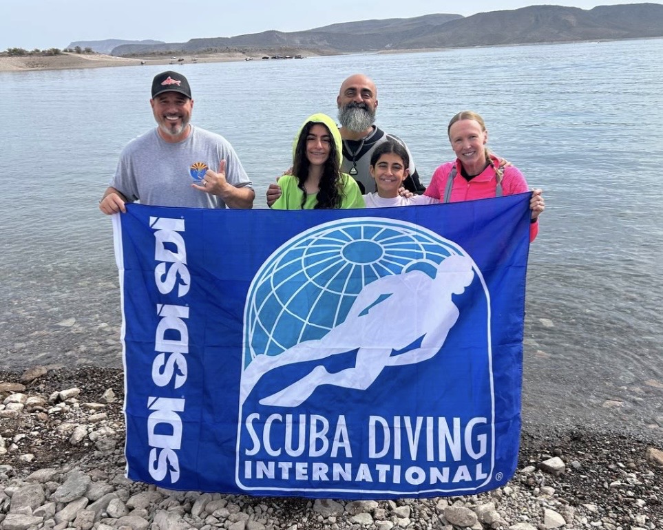 Dive Arizona students and instructors with an SDI dive flag on the shore of Lake Pleasant