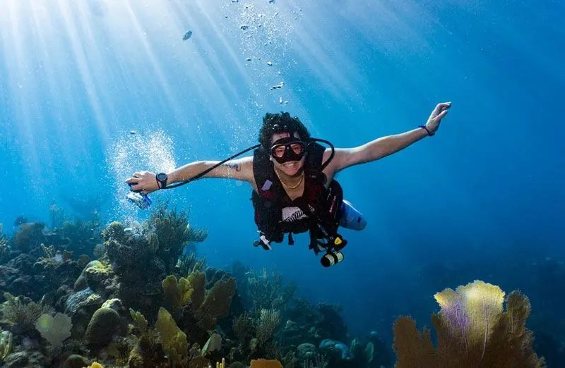 A smiling scuba diver over the reef in Roatan