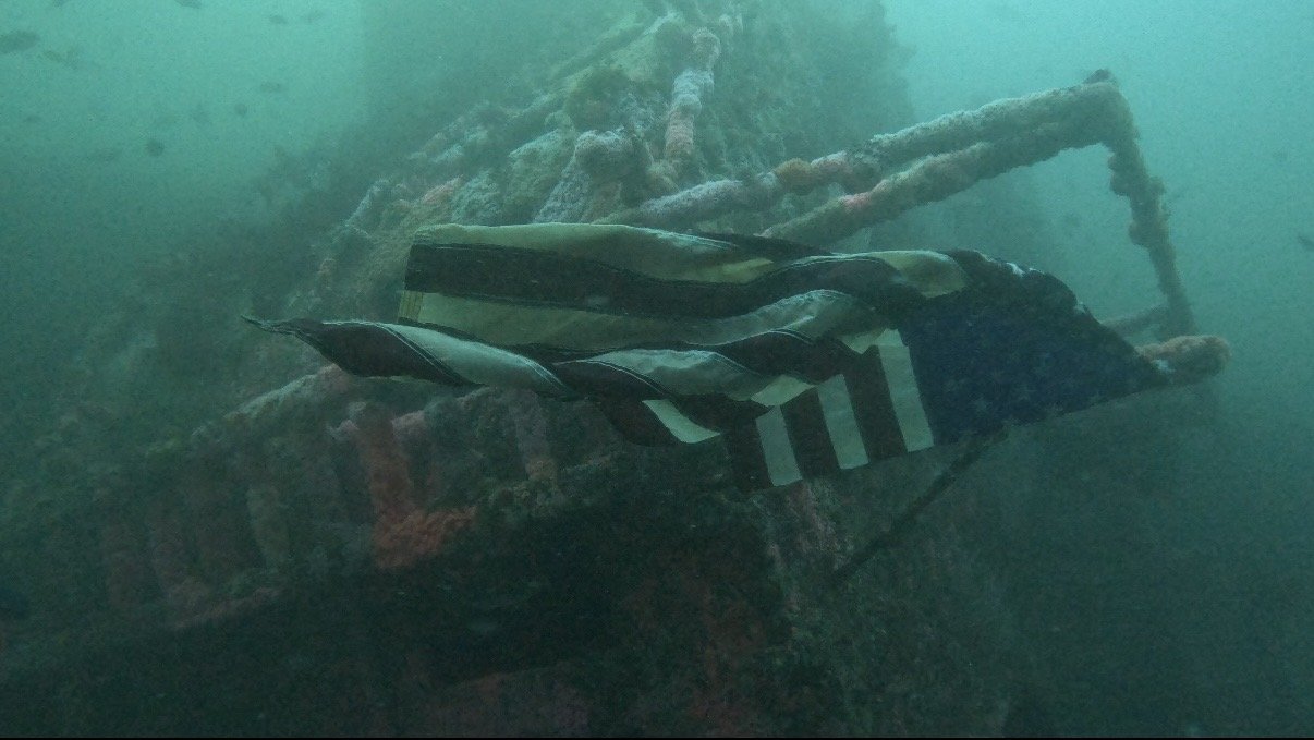 A wreck in San Diego's Wreck Alley draped with an American flag