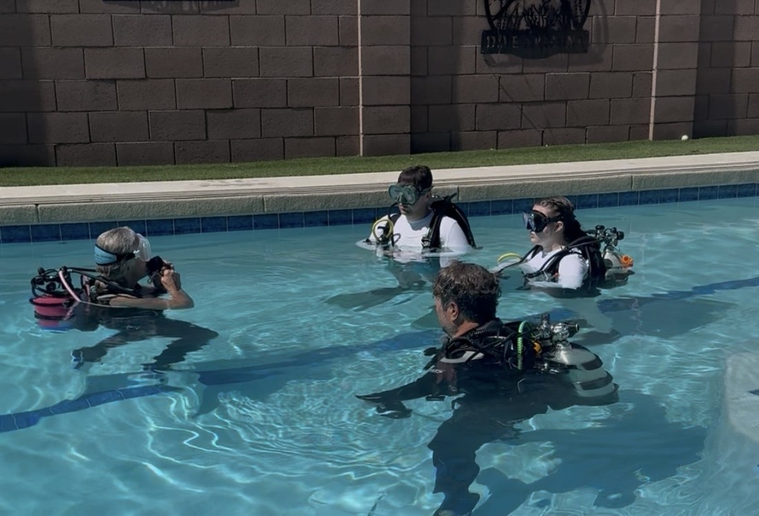 Divers in full scuba gear practicing skills together in a pool during a Dive Arizona refresher session