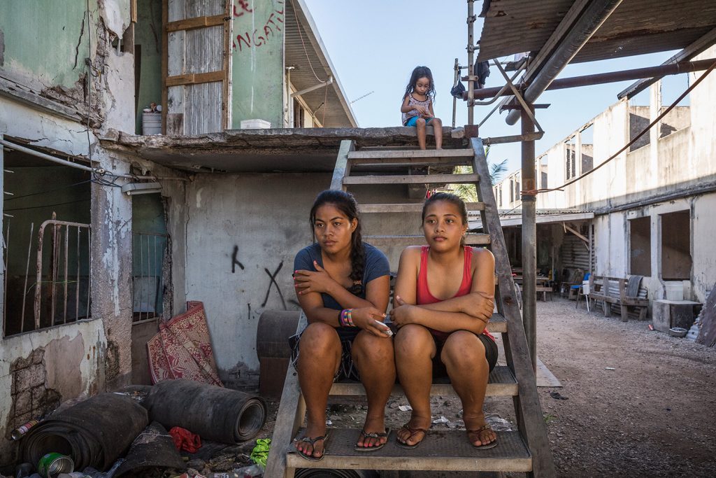 Tewira (19, left) and Lusia (14, right) sit on the stairs in front of their family house in the Location Block. Their parents came to Nauru from Tarawa, Kiribati looking for work and a better future for their children. Soon after Nauru started having economical problems in the early 2000s, they and many other people lost their jobs and became squatters in the Location Block Area. Location Block was a residential area for foreign miners who came to Nauru to work on the phosphite mine. After the closure of the mine in the early 2000s most of the miners left Nauru and the Location Block became a squatters settlement, mostly populated by locals. Image by Vlad Sokhin