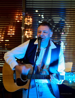 Jason Didner performing live on acoustic guitar at The Fine Grind. Photo by Dennis Hill