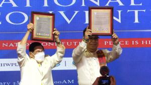 Chairman Lee Man Hee and Commissioner Ronald Adamat raise their shared award