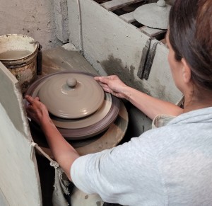 A potter finishing MEC lid