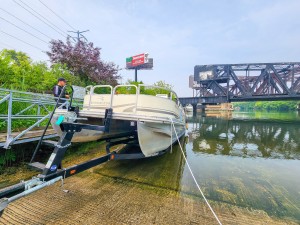 Ken Carwell (left) looks on as Dave Hanson (in boat) docks at DuSable Harbor for the first time