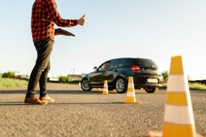 instructor helps female student drives cones lesson driving school