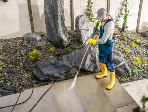 Pressure washing employee power washing cement