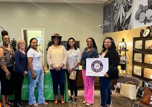 Chamber President, Shell McClue, (right) holds sign at local business mixer