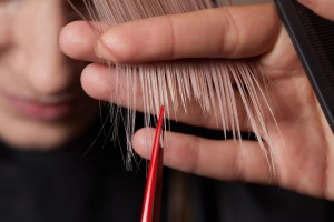 hands hairdresser hold hair strand his fingers making haircut long hair young woman with comb scisso