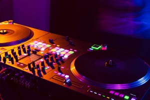close up of dj mixing console in party light