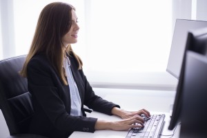 smiling Kirsten Poon sitting typing computer