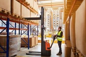 employee working on warehouse with boxes on shelves worker operator using reach truck