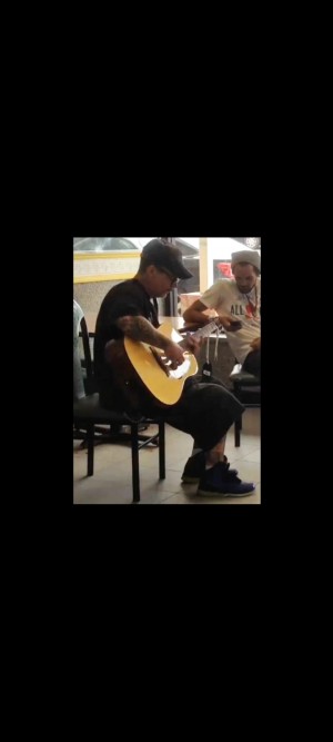 Brett captivating a crowd at a restaurant with his guitar playing.