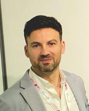Close up portrait of Pedro Oliveira in a gray blazer