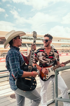 Jordan Miller and Kristian Cruz at the Cyber Rodeo Cybertruck Meetup, in front of a Cybertruck stage