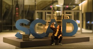 Aaron Nelson, founder, with SCAD sign