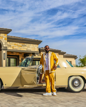 Luxury in motion Willy Northpole steps out in the Gold Standard Tracksuit beside a 1956 Lincoln MKII