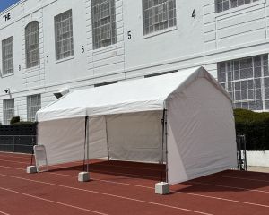 Track field tent setup with PA speakers for DJ and announcements at the 2024 Student Run LA Marathon
