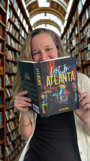 Jen Ventures holds a copy of her debut novel Lost in Atlanta at the official book reveal event.