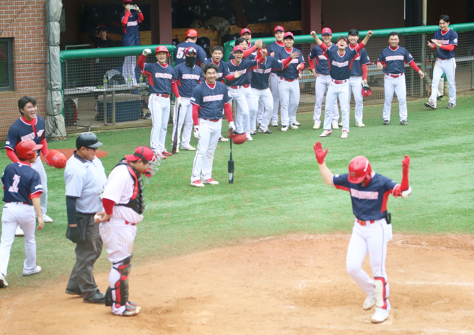 A Shincheonji baseball player crosses home plate after hitting a home run