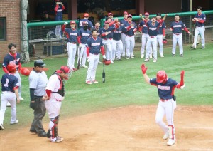 A Shincheonji baseball player crosses home plate after hitting a home run.