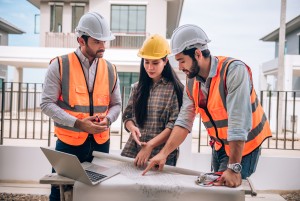 civil engineer construction worker architects wearing hardhats safety vests are working together con