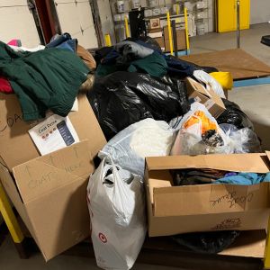 Cousino Restoration staff with cleaned, bagged coats ready for annual coat drive.