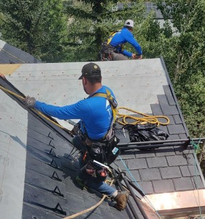 Everest EG 16 snow guards being installed on DaVinci Slate roof by Umbrella Roofing team member.