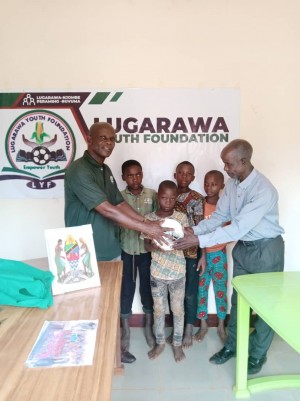 Director handing over the ball to Youth as part of tha foundation supporting in sports