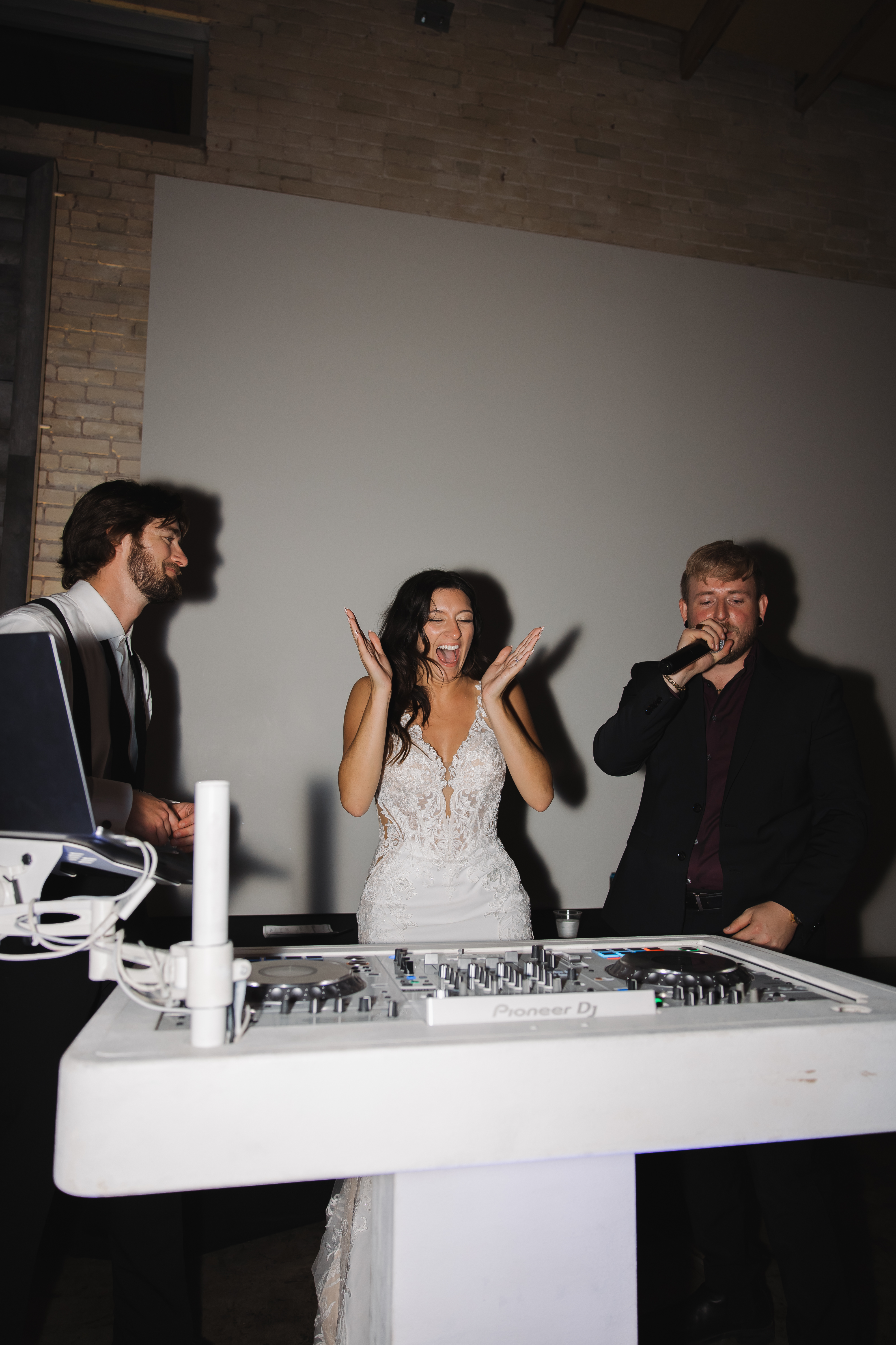 Bride at white Pioneer DJ booth at Greenville SC wedding reception by Ros Weddings  Events