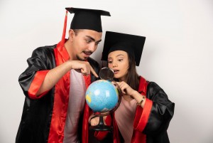 imgi 32 pair enthusiast students gown looking globe with magnifying glass 114579 53805