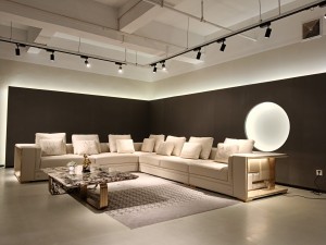 An upholstery swatch is compared with a sofa surface to check color and texture consistency.
