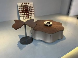 Coordinated upholstery, stone-pattern surfaces and metallic accents in a living room furniture displ