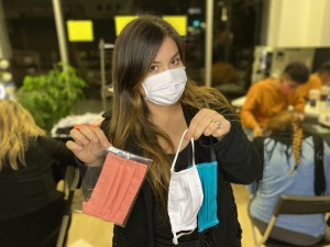 Osyley Founder, Osiris Ley, holding a few of the face masks being handmade.