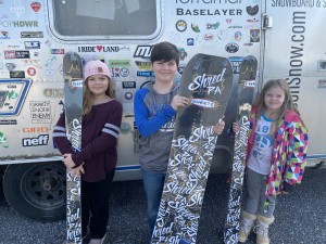A family in for a tour while picking up their skis and snowboard